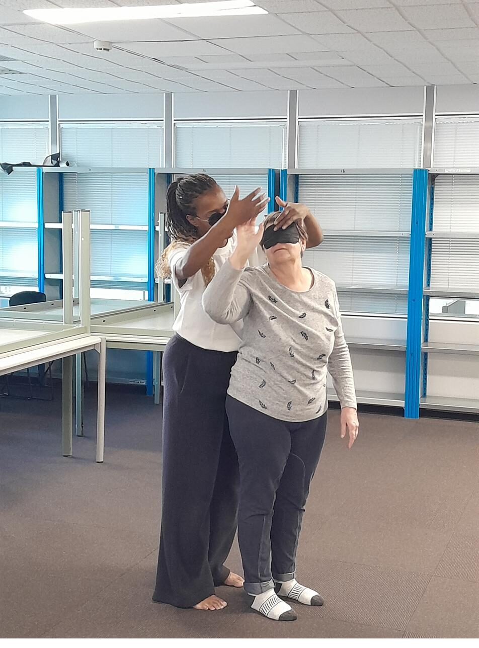 Atelier de confiance : une participante guide une personne aux yeux bandés