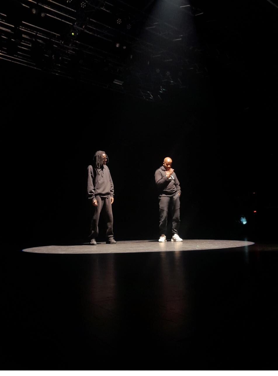 Deux interprètes face à face sur un plateau de théâtre