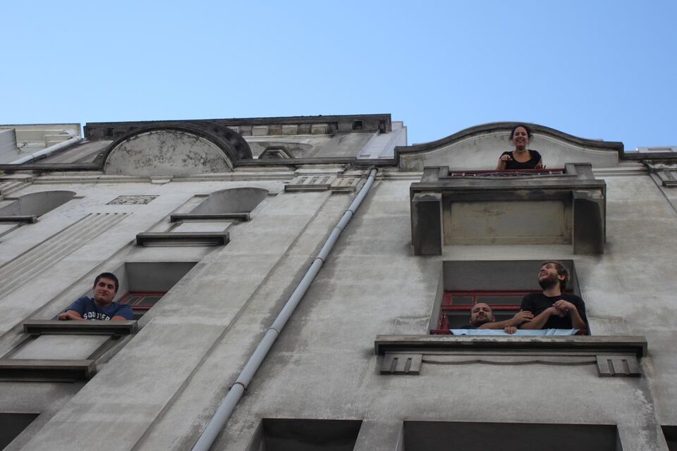 Personnes aux fenêtres d'une façade, en contre-plongée