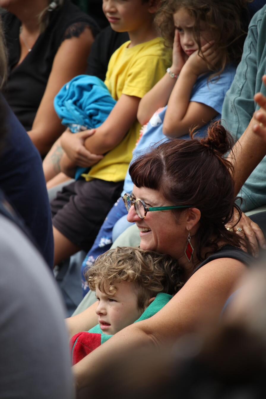 Une femme et un enfant souriants dans le public en plein air